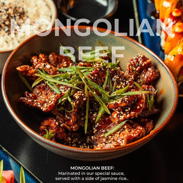Mongolian beef with sesame seeds and green onions in a bowl, with rice and sushi in the background.